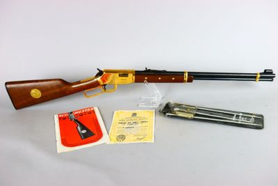 un fusil, un pistolet et d'autres objets posés sur une table