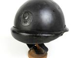 un vieux casque noir avec une base en bois sur fond blanc