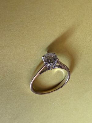 une bague en diamant posée sur une surface jaune