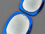 une paire d'assiettes bleues et blanches posées sur une surface grise, sur fond gris