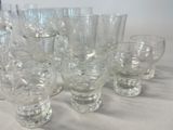 a lot of glasses sitting on a table with a white table cloth