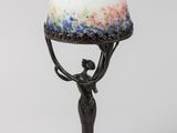 une image représentant une lampe sur laquelle une femme tient un œuf