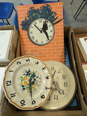a lot of different clocks and plates on the table