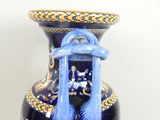 a blue vase with a blue handle on a table