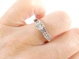 a woman ' s hand with a diamond ring on it