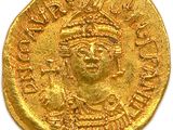 a close up of a gold coin on a white surface