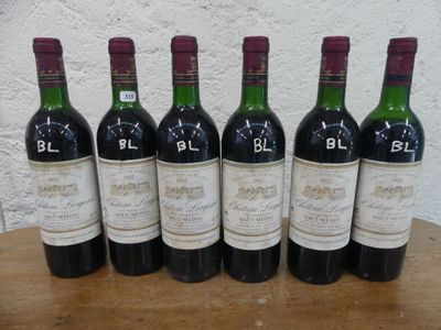 six bouteilles de vin rouge sont alignées sur une table en bois