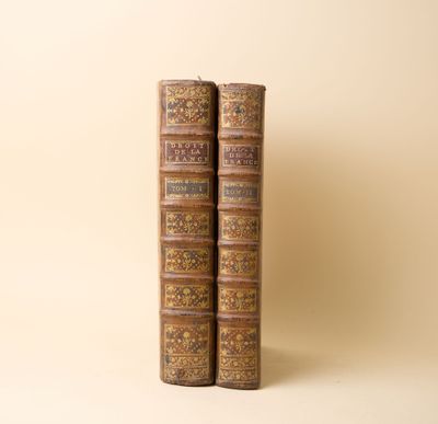 deux vieux livres posés l'un sur l'autre sur une table