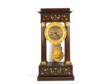 une horloge posée sur un support sur une surface blanche