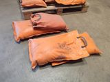 several bags of orange bags sitting on top of a wooden pallet