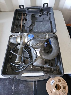 un outil dans un étui posé sur une table à côté d'une paire de ciseaux