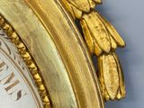 a gold clock with roman numerals on the face