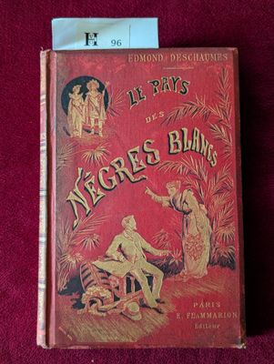 un vieux livre à la couverture rouge posé sur un tissu rouge