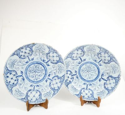 pair of blue and white plates on wooden stands