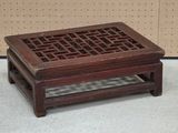 a small wooden table with a lattice design on it