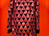 a red leather jacket with black triangles on it on a mannequin