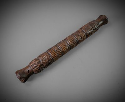 an old wooden stick with carvings on it on a table