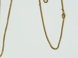two gold necklaces and a gold chain on a white background