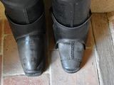 a close up of a pair of black boots on a brick floor