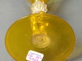 a yellow vase with a label on it on a table