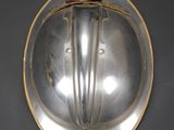 a silver plate with a face on it on a wall