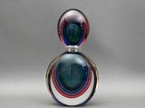 une image représentant un flacon de parfum en verre orné d'un motif multicolore