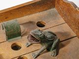 a frog that is sitting on top of a wooden box