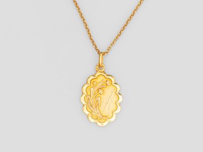 un collier plaqué or avec un pendentif en forme de fleur au bout d'une chaîne