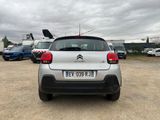 the rear of a small silver car parked in a parking lot