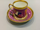 a cup and saucer sitting on a white table
