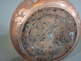 a close up of a copper vase with a hole in it