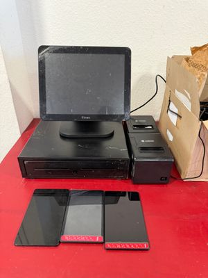 une table rouge sur laquelle se trouvent un ordinateur portable, un téléphone et d'autres appareils électroniques