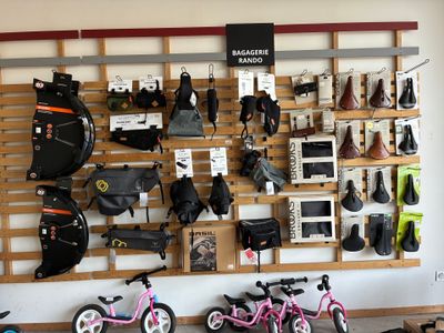 de nombreux vélos et sacoches accrochés au mur du magasin
