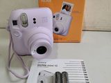 an image of a purple camera sitting on top of a table next to two batteries