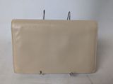 a beige leather purse with a metal hook on it