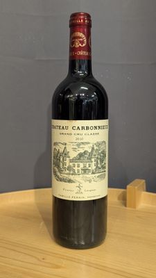 une bouteille de vin rouge posée sur une table en bois