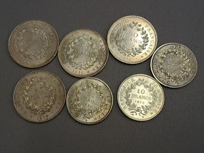 six types différents de pièces d'argent sur une surface noire