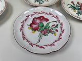 four plates with flowers painted on them on a table