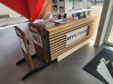 a wooden table with a sign on it in front of a window