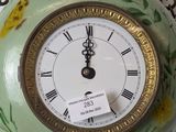 a clock that is hanging on a chain on the wall