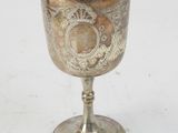 a silver goblet sitting on a white surface
