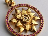 un pendentif en or orné d'une fleur au centre