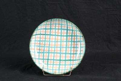 assiette à carreaux verts et orange sur un support