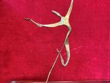 bronze sculpture of a dancing woman on a red background