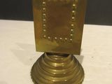 a gold candle holder on a white table cloth
