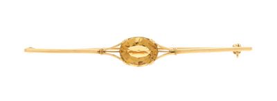 a close up of a gold tie bar with a faceted citrine stone