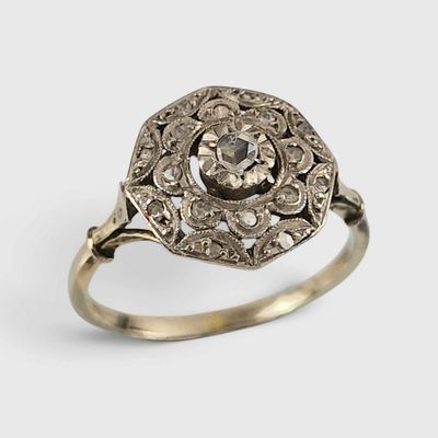 gros plan d'une bague en or et diamants sur fond blanc