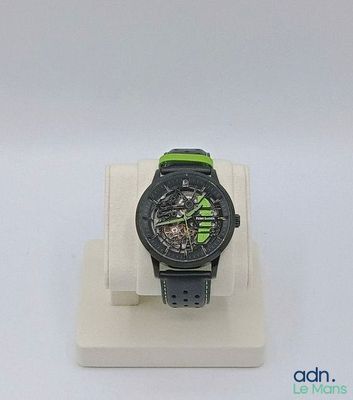 une montre noire et verte posée sur un présentoir