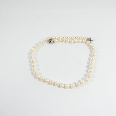 un collier de perles blanches avec un fermoir en argent sur fond blanc