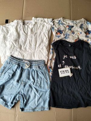 Deux paires de shorts et un t-shirt sont posés sur une boîte en carton